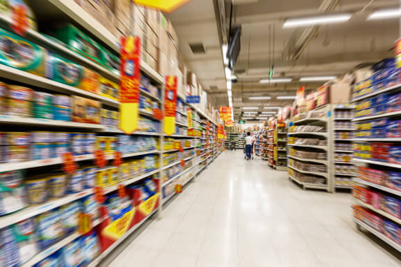 Alimentos e Bebidas: Imagem de corredor em um supermercado com prateleiras cheias de alimentos e bebidas de diferentes marcas e tipos